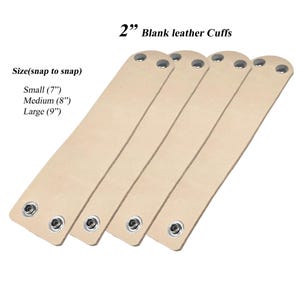 May include: Four blank leather cuffs in a light beige colour. Each cuff is 5.08 cm wide and has snaps for closure. Sizes available are small (17.78 cm), medium (20.32 cm), and large (22.86 cm).