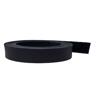 May include: A rolled-up strip of black leather, likely for crafting or repair. The leather appears smooth and has a matte finish. The roll is tightly wound, showing the thickness of the material. The background is plain white.
