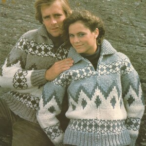 May include: Two people wearing gray and white patterned sweaters with a zipper closure. The sweaters have a diamond pattern and a geometric design. The sweaters are made of a soft, knitted fabric.