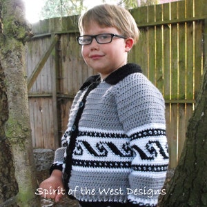 May include: A gray and black crocheted cardigan with a black collar and white trim. The cardigan has a pattern of black waves on the white trim. The cardigan is buttoned up and the child wearing it is smiling.