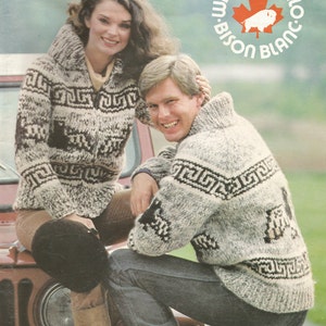 Op de afbeelding: Twee mensen dragen witte en zwarte gepatroneerde truien. De man draagt ​​een blauwe jeans en de vrouw draagt ​​een bruine broek en laarzen. De truien zijn gemaakt van pure virgin wool. De afbeelding bevat de tekst "White Buffalo Bison Blanc" en "Pat. 16".