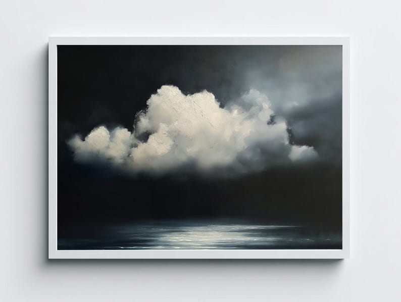 May include: A framed landscape painting depicts a dramatic sky with a large, fluffy white cloud against a dark, moody background. The bottom of the painting shows a reflective body of water, with the white frame adding a clean border.