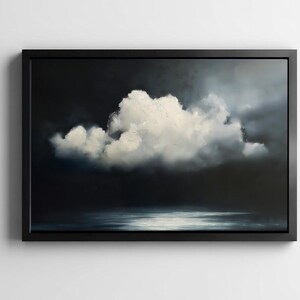 May include: A framed artwork depicting a dramatic cloudscape. A large, fluffy white cloud dominates the center against a dark, moody background. The artwork is framed in a simple black frame, creating a striking contrast.