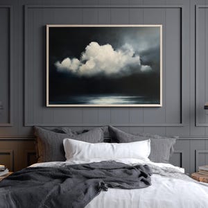 May include: A framed painting of a dramatic cloudscape hangs above a bed with gray and white bedding. The artwork features a large, white cloud against a dark, moody background. Two pendant lights flank the bed, adding to the room's ambiance.