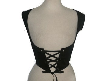 May include: Black corset-style top with a lace-up back. The top is sleeveless and has a scoop neckline. The back features a criss-cross ribbon design for adjustable fit. The garment is displayed on a mannequin.
