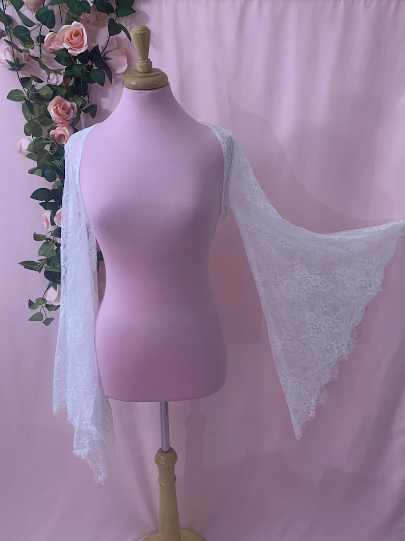 Close-up shot of the white lace fabric highlighting the delicate eyelash fringe details and intricate floral pattern.
