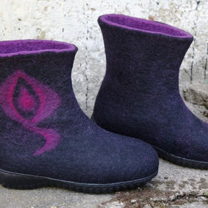 May include: A pair of black felt boots with purple lining and a pink and purple design on one boot.