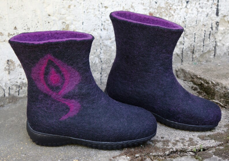 May include: A pair of black felt boots with purple lining and a pink and purple design on one boot.