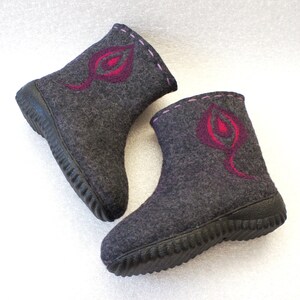 May include: Two pairs of gray felt boots with pink and red leaf designs. The boots have a black rubber sole with a textured tread.