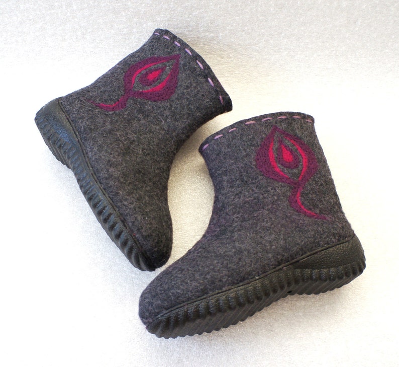 May include: Two pairs of gray felt boots with pink and red leaf designs. The boots have a black rubber sole with a textured tread.