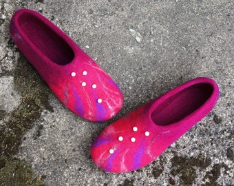 May include: A pair of pink and purple wool slippers with white pearl embellishments. The slippers have a tie-dye pattern.