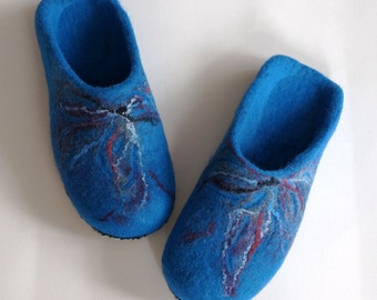 May include: A pair of blue wool slippers with a colorful abstract design. The slippers are made of felted wool and have a soft, comfortable feel.