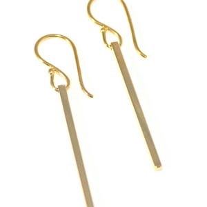 Square gold bar earrings on a white background.