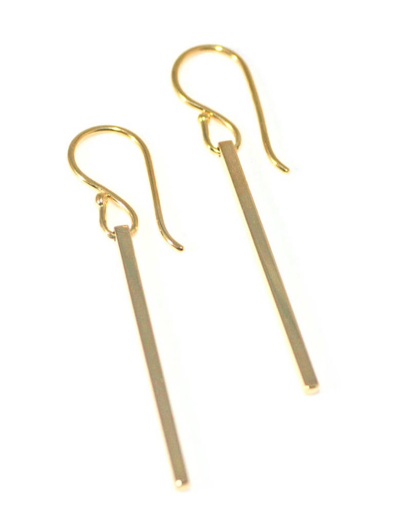Square gold bar earrings on a white background.