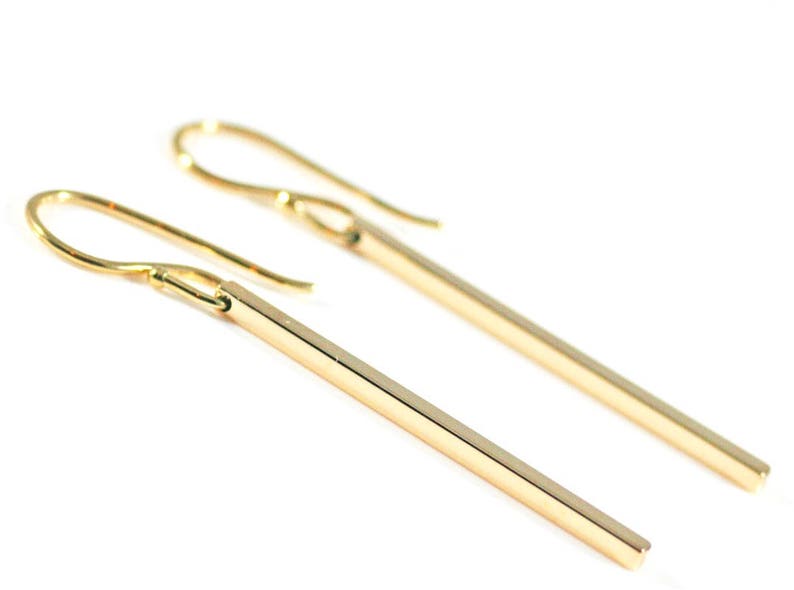 Square gold bar earrings on a white background.