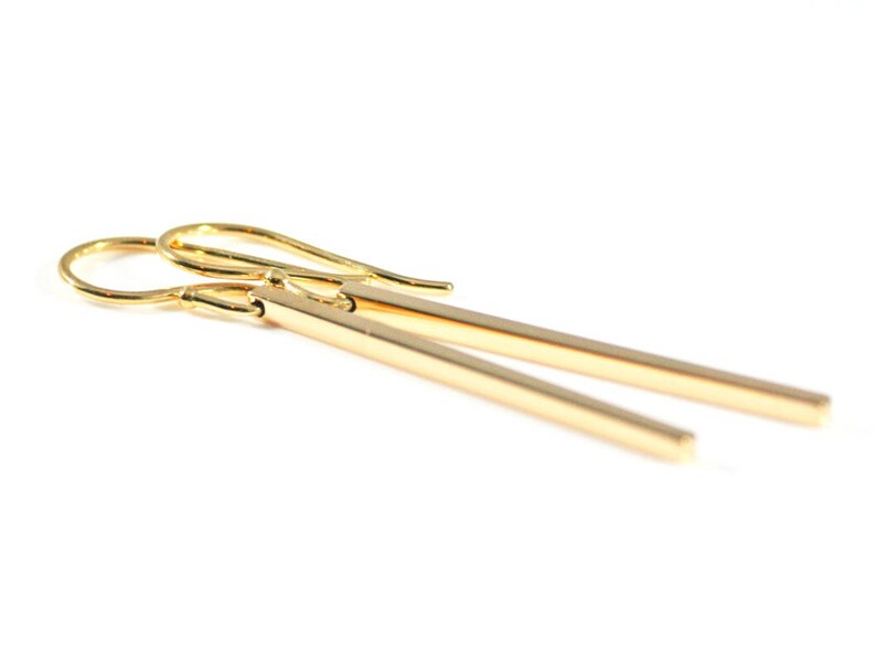 Square gold bar earrings on a white background.