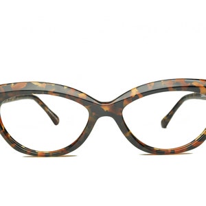 May include: Tortoise shell cat eye glasses with clear lenses.