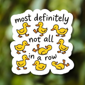 May include: A white sticker with the text "most definitely not all in a row" and illustrations of yellow cartoon ducks. The ducks are in various poses, some walking, some lying down.