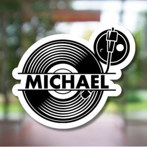 May include: Black and white vinyl record sticker with the name "MICHAEL" in bold, capital letters. The design includes a turntable arm and a circular record label.