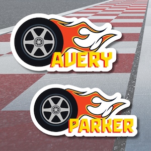 May include: Two stickers featuring a black tire with a silver rim and orange flames. The word "AVERY" is in yellow and red, and the word "PARKER" is in yellow and red.