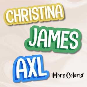 May include: Three name stickers: "CHRISTINA" in yellow, "JAMES" in green, and "AXL" in blue, each with a white outline and shadow. The text "More Colors!" is in black, below the stickers.