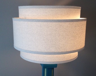 3-Tier 18" hardback lamp shade in off-white muslin fabric with edge trimming, best for floor lamps or large table lamps.