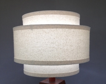 3-Tier 12" hardback lamp shade in muslin fabric with edge trimming.