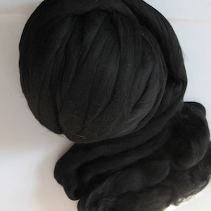 May include: A large ball of black wool yarn. The yarn is soft and fluffy, and it is perfect for knitting or crocheting.