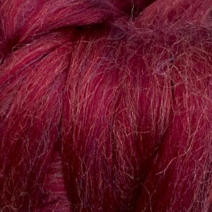 May include: Close-up of a deep burgundy colored yarn with a soft, fuzzy texture.