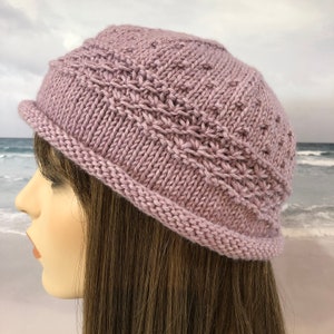 May include: A soft, knitted hat in a light purple colour. The hat has a simple, classic design with a wide brim.