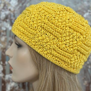 以下が含まれることがあります： テクスチャのある模様の入った黄色のニットのビーニー帽