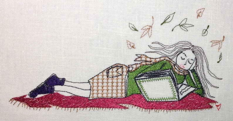 May include: An embroidered image of a person lying on a red blanket, reading a book. The person wears a green jacket, a scarf, and a skirt. Autumn leaves are falling around the person. The image is on a white background.