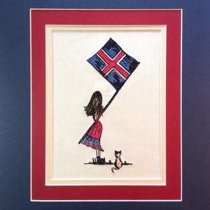 May include: Embroidered artwork featuring a girl in a red dress holding a blue and white flag with a red cross. A small cat is standing behind her.