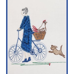 Può includere: Opera d'arte ricamata raffigurante una persona in bicicletta con un cesto contenente una gallina. Un cane marrone corre accanto. La persona indossa un vestito blu. L'opera ha un bordo blu.