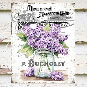 Peut inclure: Une enseigne de style vintage avec le texte "MAISON NOUVELLE 25, Rue des Cordeliers P. DUCHOLET" en lettres noires sur fond blanc. Un bocal en verre rempli de fleurs de lilas violettes repose sur une surface blanche.