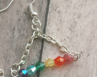 May include: Silver chain earrings with a rainbow of crystal beads. The beads are in the order of red, orange, yellow, green, blue, and purple.