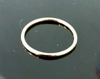 May include: A simple gold ring, a thin band of metal, on a black background.