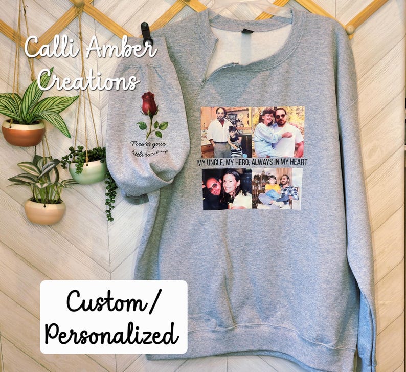 May include: A gray sweatshirt with a custom design. The design includes a rose graphic, the text "Forever your little rose", and a collage of photos. The text "My uncle, my hero, always in my heart" is also printed on the sweatshirt. The words "Custom/Personalized" are also visible.