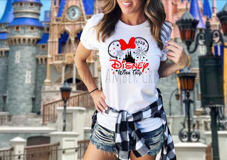 May include: White t-shirt with a black and red graphic of Mickey Mouse ears with a bow and fireworks. The text "Disney Wish Trip" and "2023" are on the shirt.