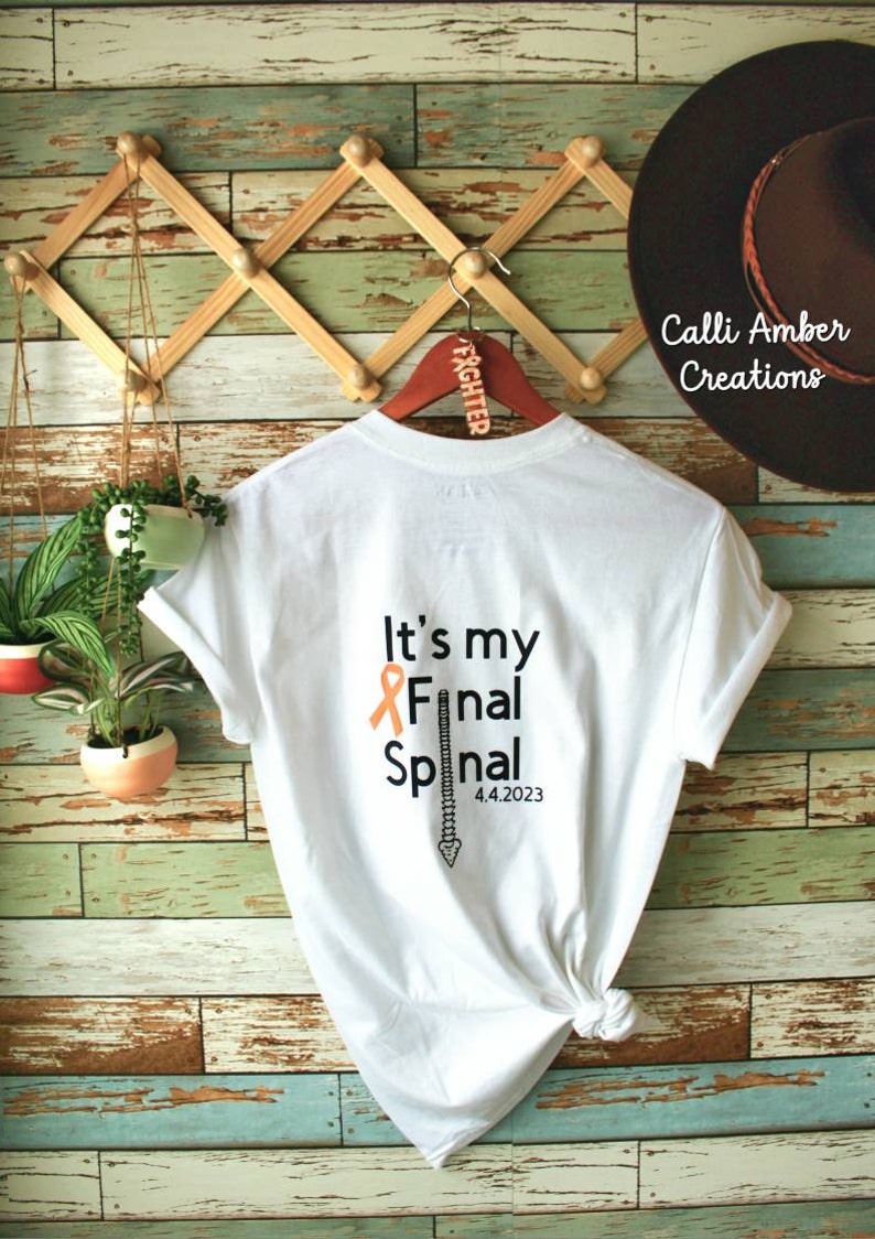 May include: White t-shirt with the text "It's my Final Spinal" and an orange ribbon. The text "4.4.2023" is below the spinal graphic.