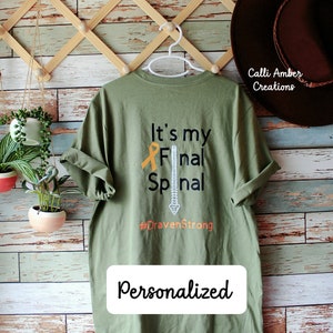 May include: A green t-shirt with the text "It's my Final Spinal #DravenStrong" and a stylised image of a spine. The text "Personalized" is printed below the design.