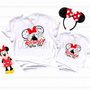 May include: Two white t-shirts with a black and red graphic of Mickey Mouse ears, a castle, fireworks, and the text "Disney Wish Trip 2023".