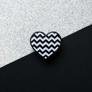 May include: Black and white chevron pattern heart-shaped enamel pin.