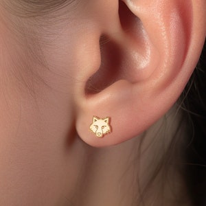 May include: Gold wolf head stud earrings. The earrings are small and delicate, and they are perfect for everyday wear.