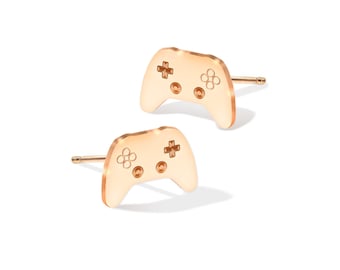 Può includere: Un paio di orecchini a bottone dorati a forma di controller per videogiochi.