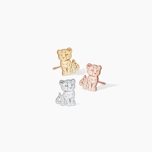 May include: Three cheetah stud earrings in gold, rose gold, and silver.