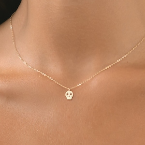 May include: A gold chain necklace with a small, detailed skull pendant.