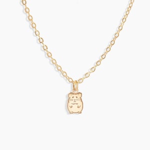 May include: A gold chain necklace with a small hamster charm pendant.