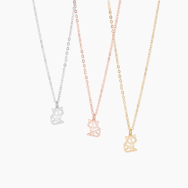 Puede incluir: Tres delicados collares con colgantes de zorro de origami. Los collares son de plata, oro rosa y oro.