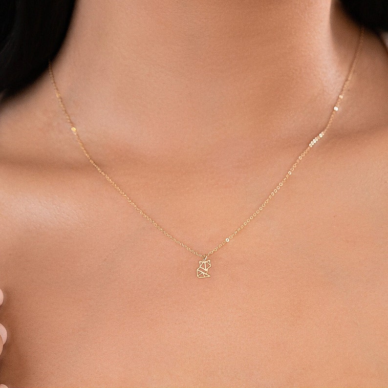 Puede incluir: Un delicado collar de cadena dorada con un peque&ntilde;o colgante de zorro geom&eacute;trico.